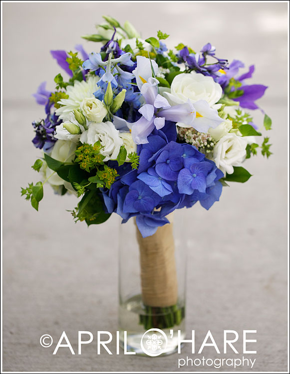 A bridal bouquet made up of blue and purple and white flowers